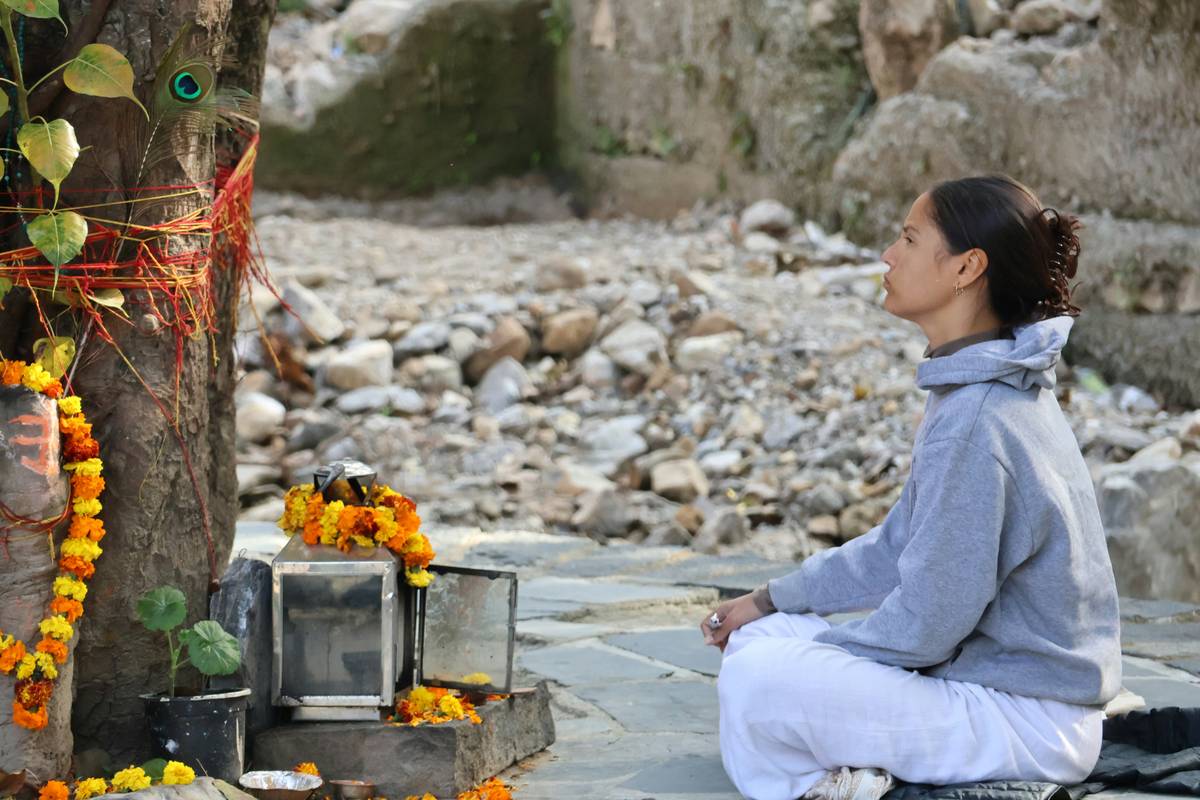 A person sitting cross-legged indoors surrounded by candles practicing Zen meditation.
