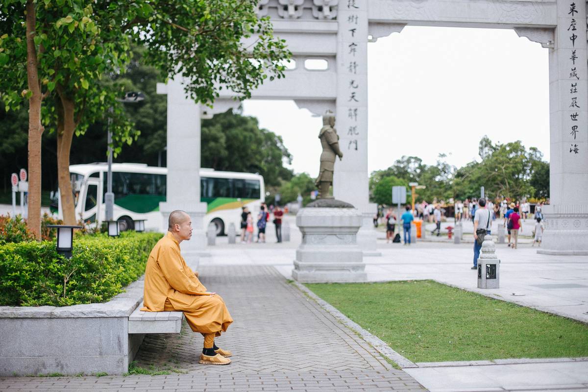 A woman meditating while commuting using her smartphone.